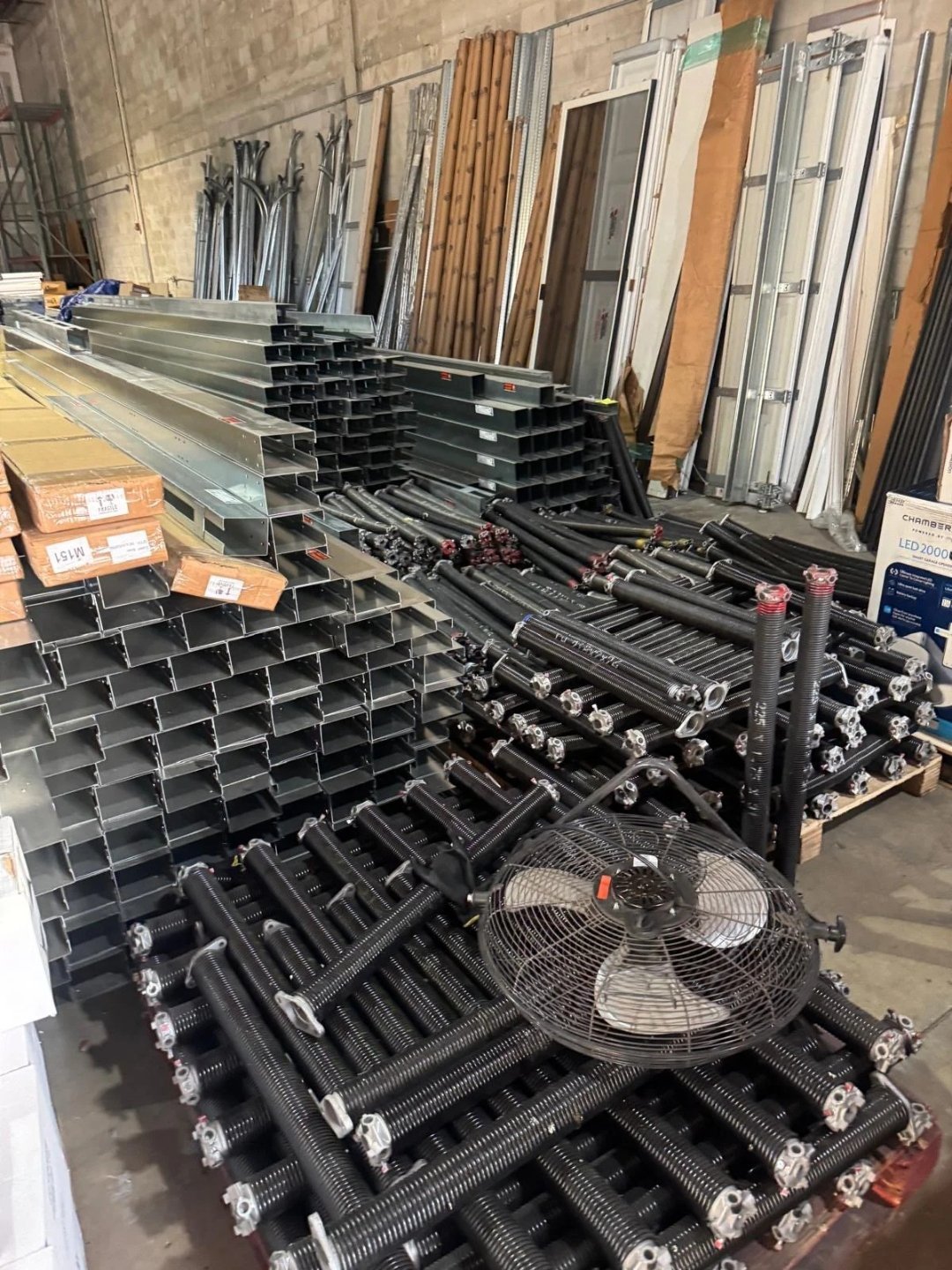 Stacks of steel track and garage door hardware in a parts warehouse