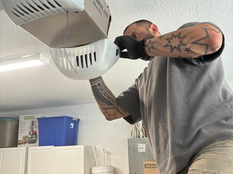Technician checking the light and housing of a garage door opener