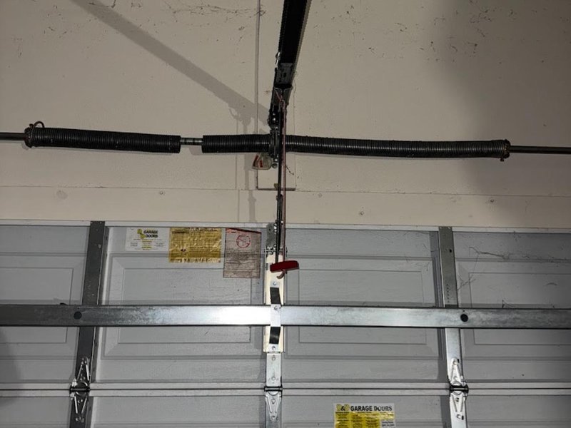 Torsion spring and center bracket above a closed garage door